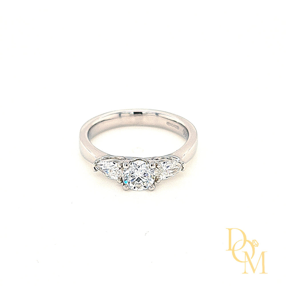 Platinum 3 stone engagement ring. Round centre in a four claw setting with a pear cut diamond on either side