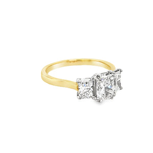 View from the front side of Three stone radiant cut lab grown diamond ring. The larger centre is set with four double eagle claw and the smaller sides are set with four eagle claws. The ring features a plain and tapered yellow shank and the setting is in platinum