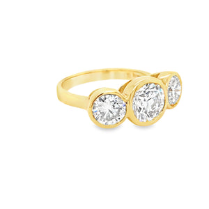 Side view of 18ct yellow gold three stone engagement ring with bezel set lab grown diamonds.