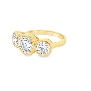 Side view of 18ct yellow gold three stone engagement ring with bezel set lab grown diamonds.