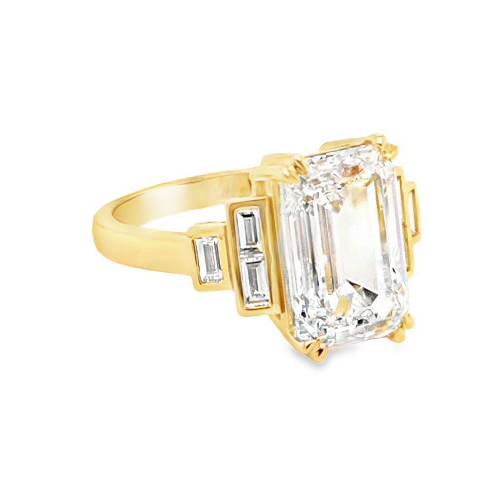 side view of Large emerald-cut lab grown diamond solitaire ring with double talon claws and stepped bezel-set baguette shoulders in 18ct yellow gold