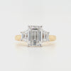 Emerald-cut lab grown diamond, four talon claws with claw set trapezoid-cut diamonds in a platinum setting with a tapered yellow gold band