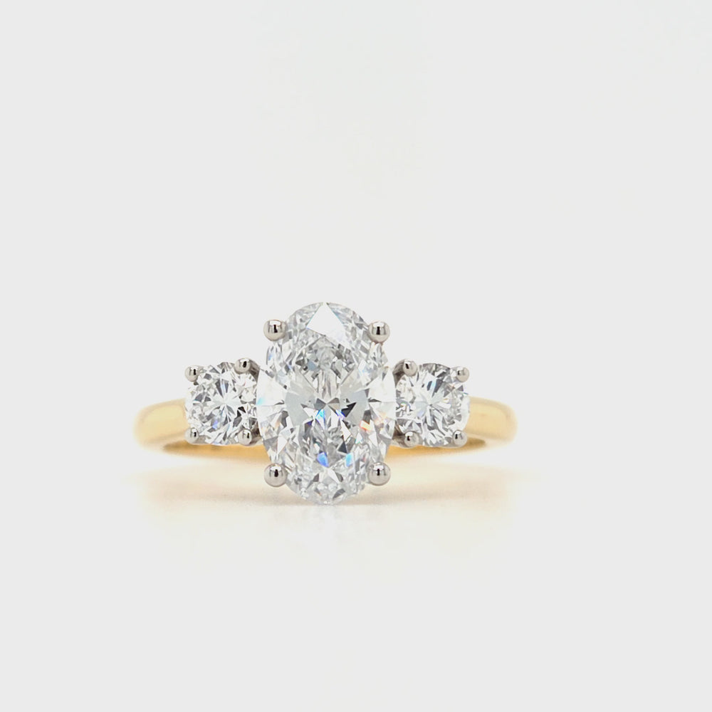 
                
                    Load and play video in Gallery viewer, An oval and two brilliant-cut lab grown diamonds each in a four claw platinum setting with a yellow gold tapered shank
                
            