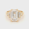 Large emerald-cut lab grown diamond solitaire ring with double talon claws and stepped bezel-set baguette shoulders in 18ct yellow gold