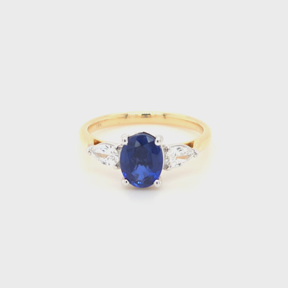 
                
                    Load and play video in Gallery viewer, 18ct gold and platinum lab grown sapphire and diamond ring showing four-claw sapphire mount and three-claw pear diamond settings.
                
            