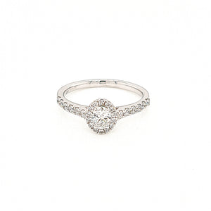 Oval diamond engagement ring. An oval cut diamond in a four claw setting, surrounded by a halo cluster of of micro claw set brilliant-cut diamonds with micro claw set diamond shoulders. 18ct white gold