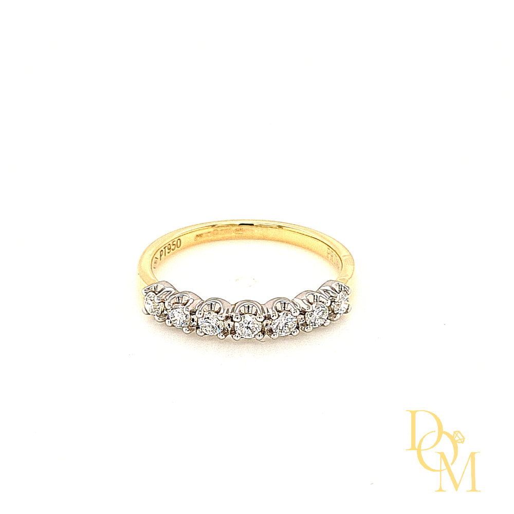 seven stone diamond ring with each diamond in a four claw platinum setting which scallops around the curve of each diamond and paired with a yellow gold band