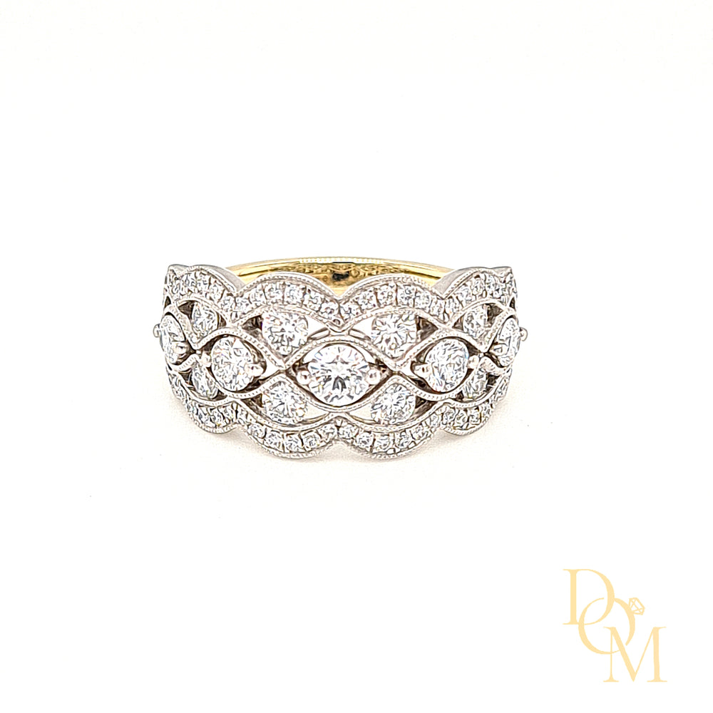 a wide flat band with three rows of diamonds, five in the centre and four in the outer rows. The outer edge had a scalloped halo cluster of pavé-set diamonds and the central part of the ring features piercing around the diamonds